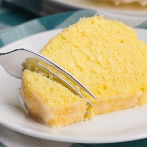 a close up of a fork cutting into a moist slice of instant pot lemon bundt cake