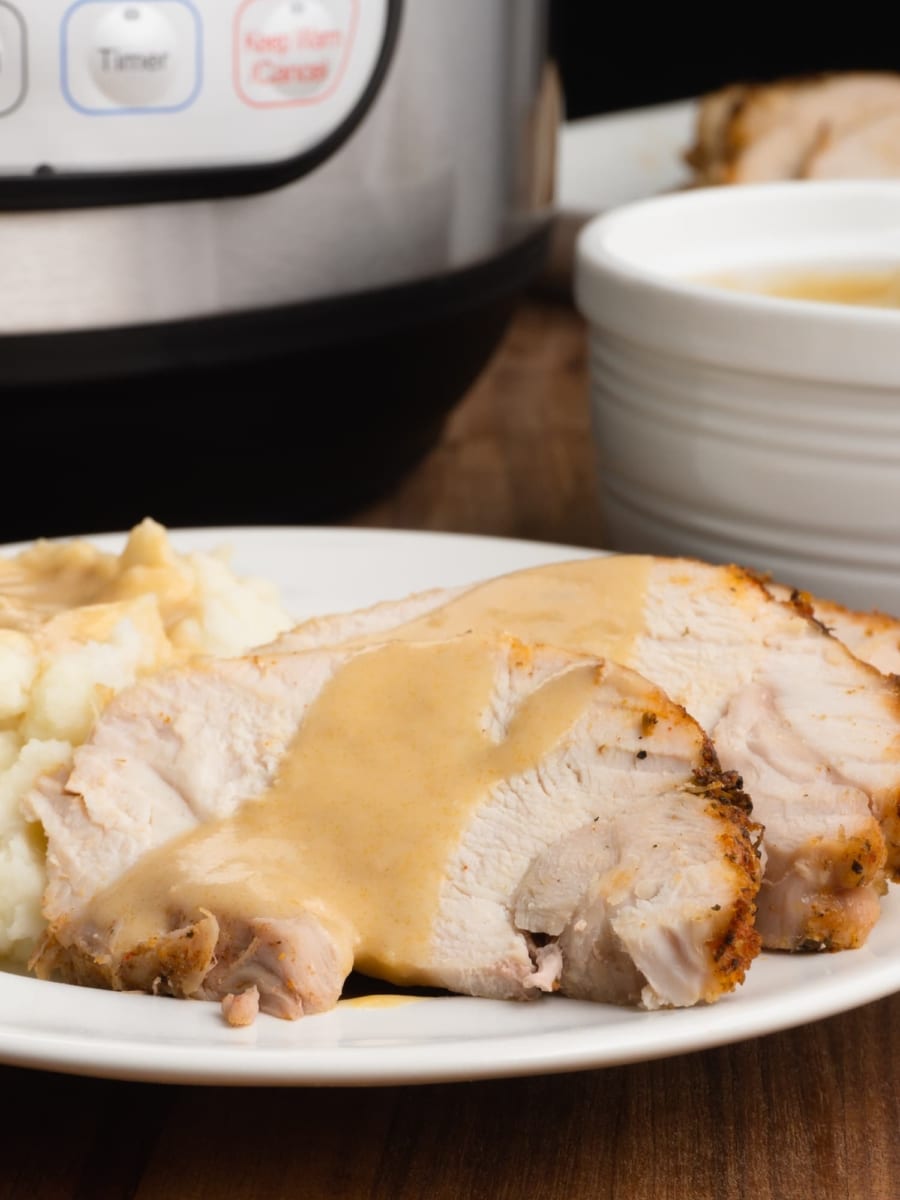 a plate of instant pot turkey roast with mashed potatoes and creamy gravy