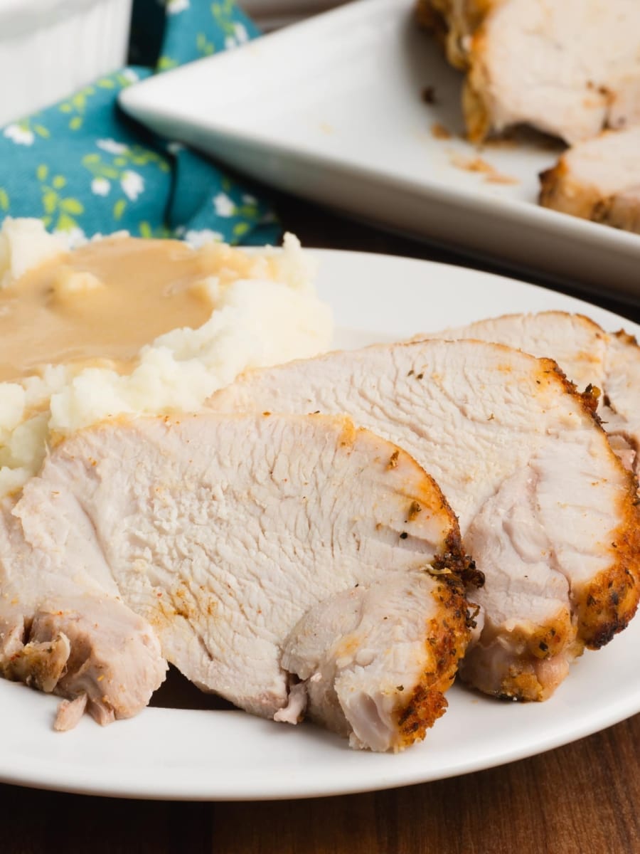 a white plate with slices of instant pot turkey roast mashed potatoes and gravy