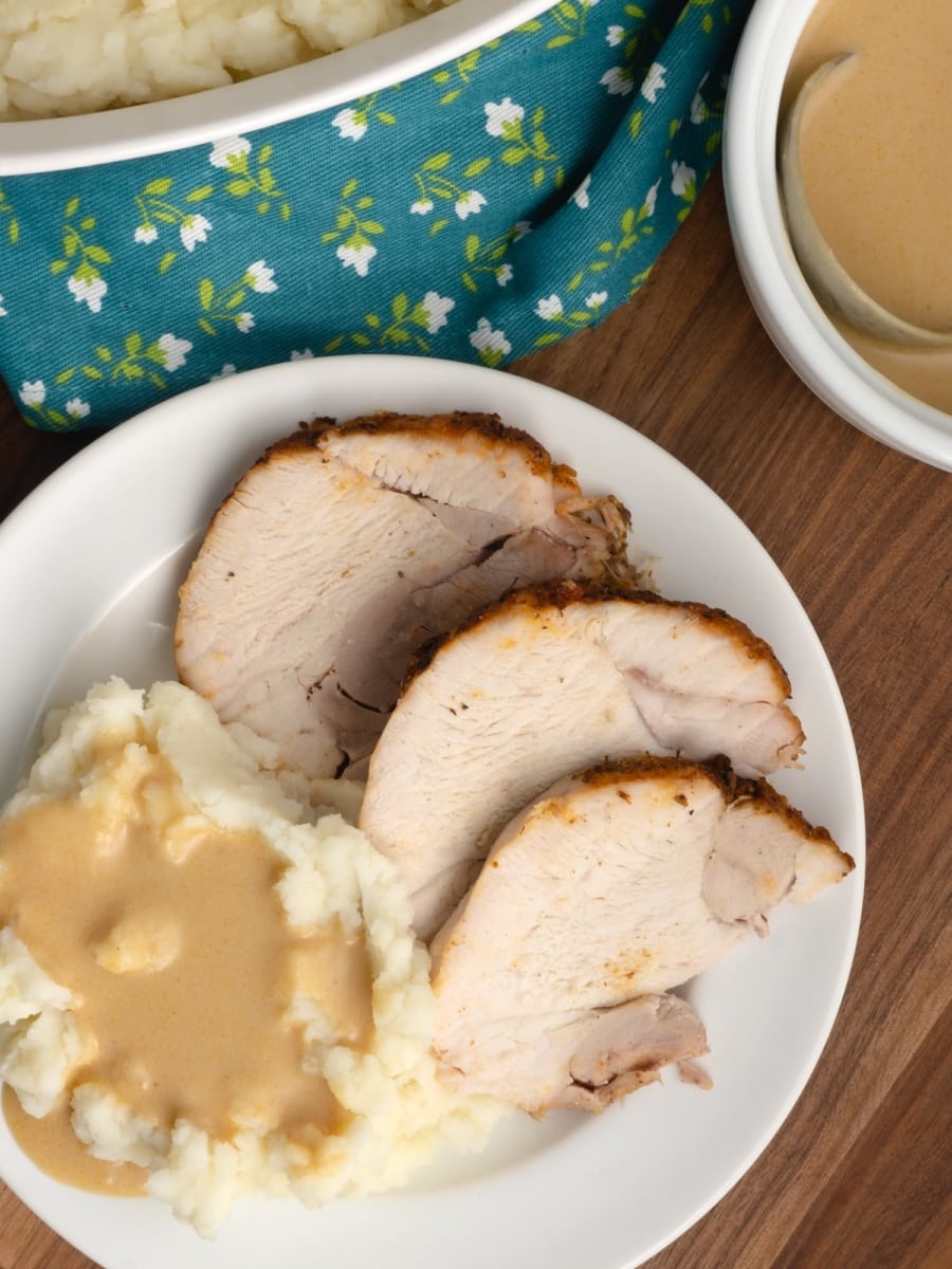 bird's eye view of slices of instant pot turkey roast with mashed potatoes and gravy