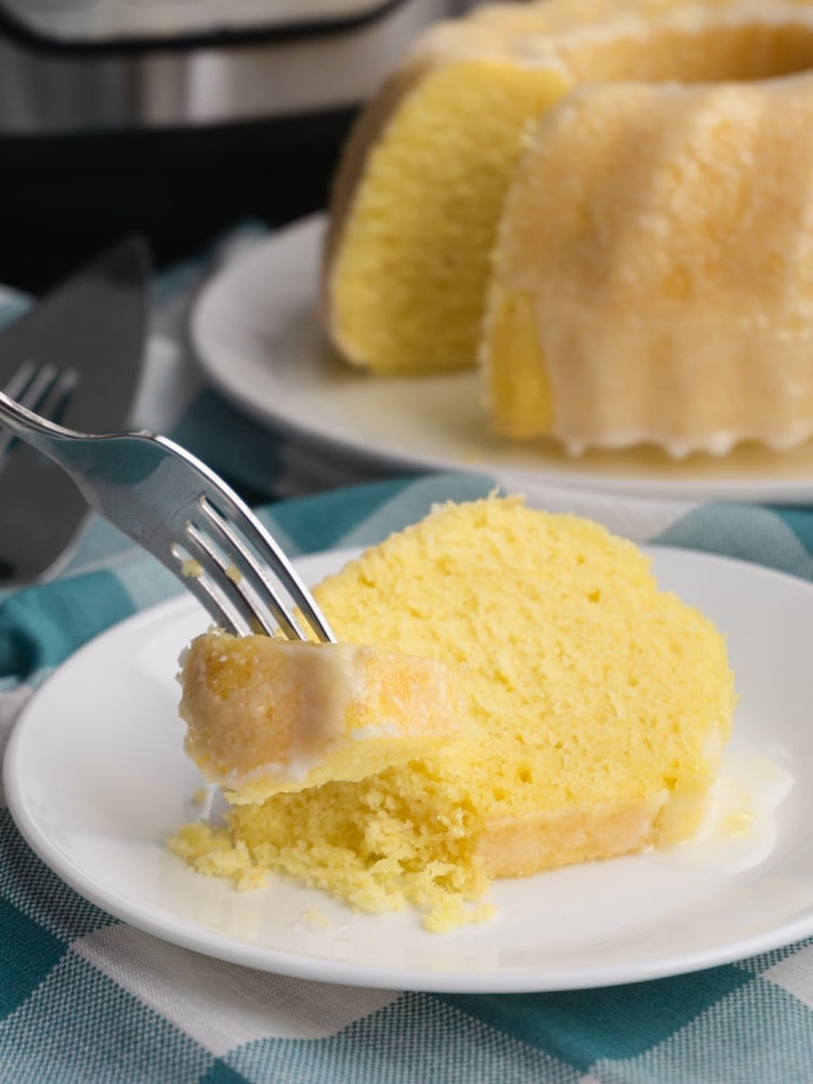 grabbing a bite with a fork from a slice of moist and fluffy lemon bundt cake