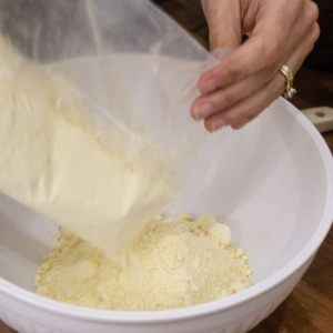 adding a lemon cake mix to a large mixing bowl