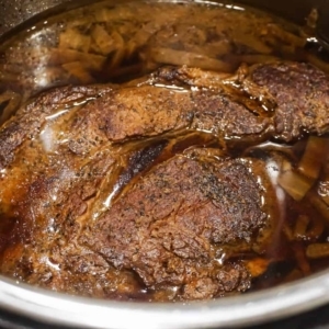 chuck roast sitting in au jus after being cooked in the instant pot