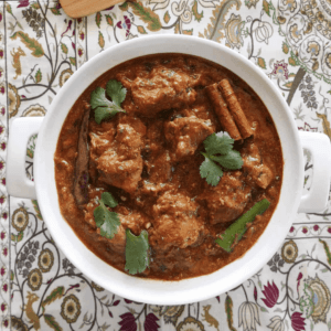 overhead shot of cashew butter chicken in a bowl garnished with cilantro