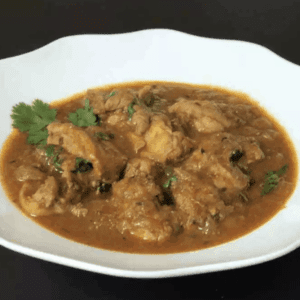 a plate of chicken curry garnished with cilantro