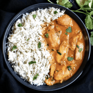 overhead shot of chicken korma in a bowl garnished with cilantro