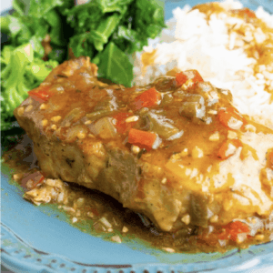 close up of pork chops and gravy served on a plate