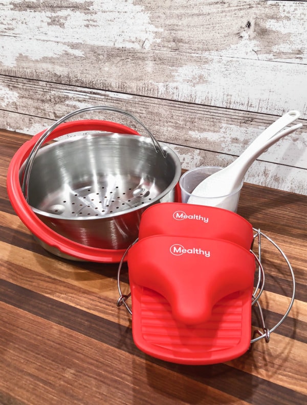 mealthy multipot accessories including a pair of silicon mitts, a steamer basket, trivet, extra silicone ring, measuring cup and a spoon and spatula