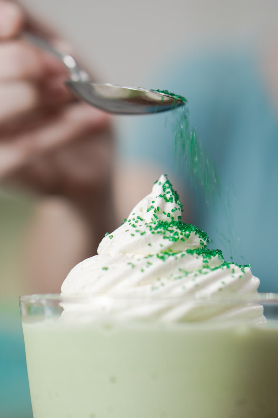 adding colored sugar to a boozy shamrock shake