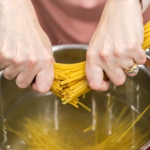 adding pasta to boiling water