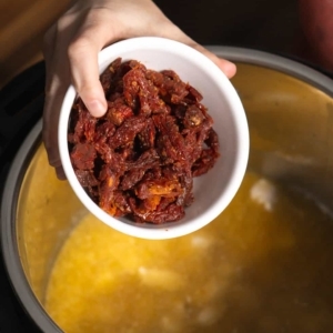 adding sun-dried tomatoes to the instant pot for tuscan chicken pasta