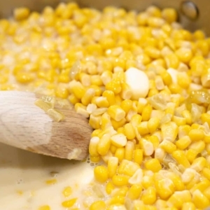 cooking and stirring corn in a skillet until the butter melts