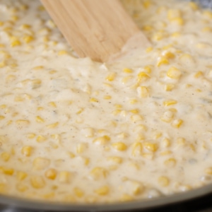 making cajun creamed corn in a skillet on the stove