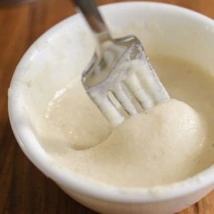 making a thickener for chili by mixing corn flour with water in a small bowl