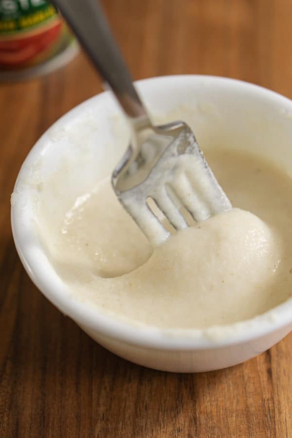 making a thickener for chili by mixing corn flour with water in a small bowl