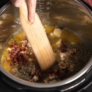 mixing ingredients for tuscan chicken pasta