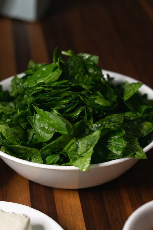 a bowl of raw spinach for making tuscan chicken pasta
