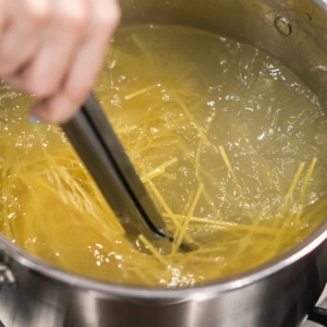 stirring pasta in boiling salt water to keep it from sticking together