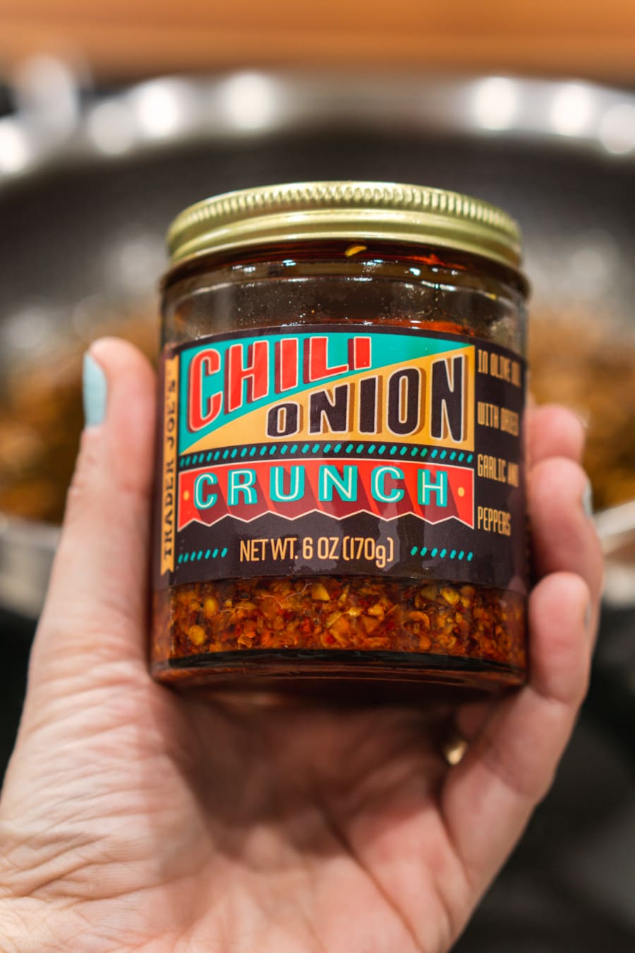 holding a jar of trader joe's chili onion crunch