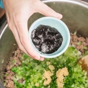 adding better than bouillon to diced vegetables and a mixture of ground beef and ground sausage in the instant pot pressure cooker