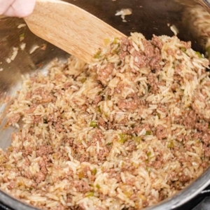 mixing cooked dirty rice in the instant pot to ensure all the ingredients are well mixed