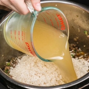 pouring chicken stock in the instant pot pressure cooker