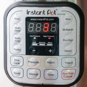 the instant pot digital display reading 3 with the high pressure and manual cook settings highlighted