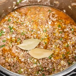 two bay leaves sitting on top of the ingredients for dirty rice in the instant pot pressure cooker