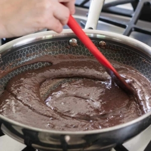 making the base for chocolate brigadeiros in a skillet on the stove