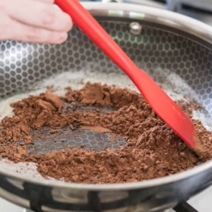 mixing cocoa powder into melted butter on a hot skillet