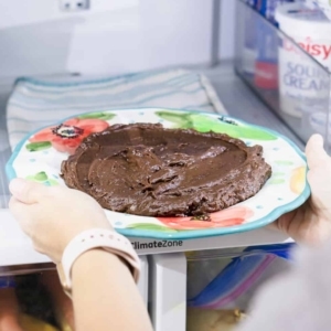 placing a plate with the chocolate base for making traditional brigadeiros into the refrigerator