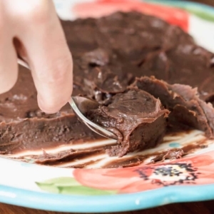 scooping chocolate brigadeiro base from a plate