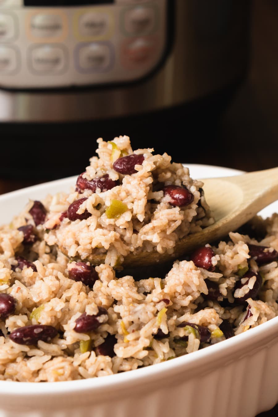 serving red beans and rice from a baking dish with a wooden spoon