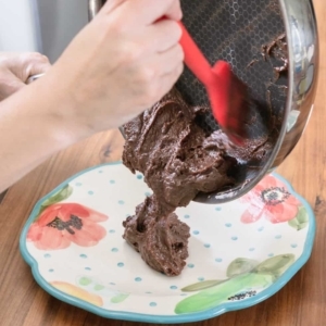 transferring the chocolate base for Brazilian brigadeiros from a nonstick skillet to a plate