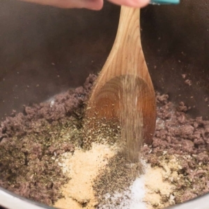 adding herbs and spices to cooked ground beef in the instant pot