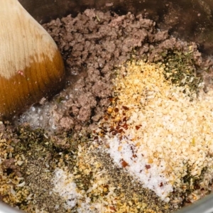 dried minced garlic, minced onion, italian seasoning, red pepper flakes, and other seasonings layered over ground beef