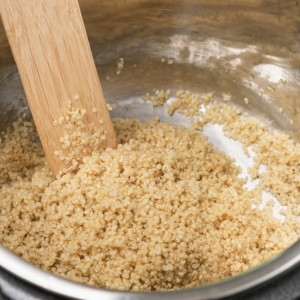 fluffing quinoa in the instant pot with a wooden spurtle