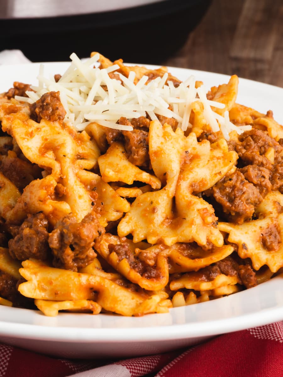 a plate of ground beef and bowtie pasta in a vodka sauce