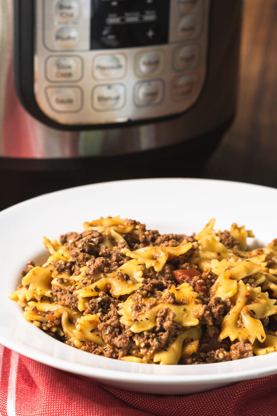 a bowl of pasta with meat sauce sitting in front of the instant pot