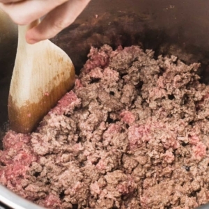 using a wooden spoon while cooking ground beef in the instant pot