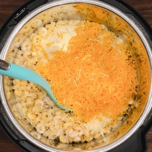 grated parmesan and shredded cheddar cheese added to cooked elbow pasta and mushroom soup in the instant pot