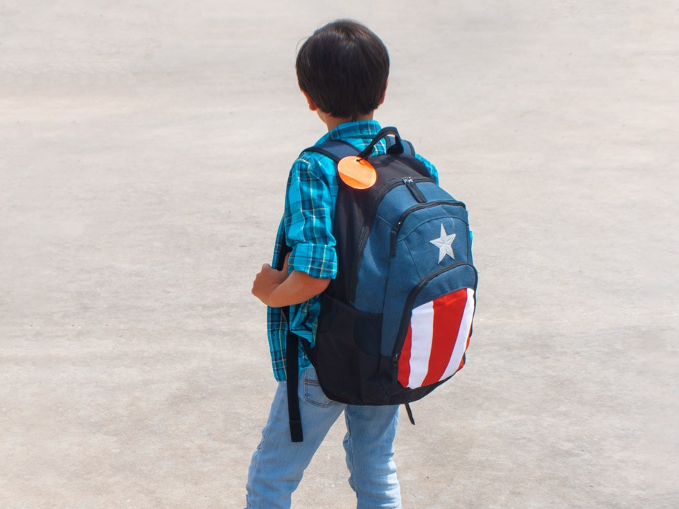 young boy heading back to school with a backpack on his back