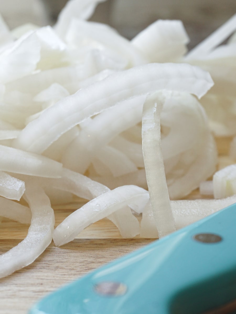 a pile of sliced onions on a cutting board