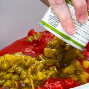 adding diced green chiles to the crockpot for making carne mechada