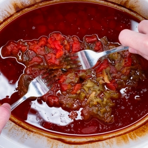 shredding a chuck roast in a crockpot to make carne mechada