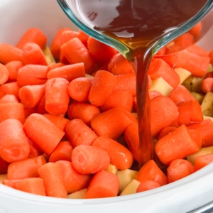 adding beef broth over vegetables for making pot roast in the slow cooker