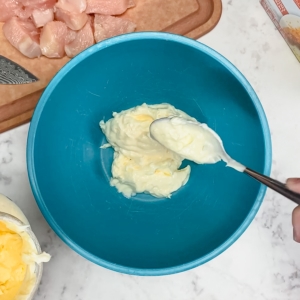 adding mayonnaise to a mixing bowl