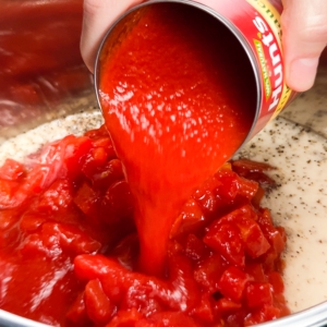 adding tomato sauce to the instant pot for making carne mechada