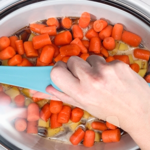 closing the slow cooker to cook pot roast