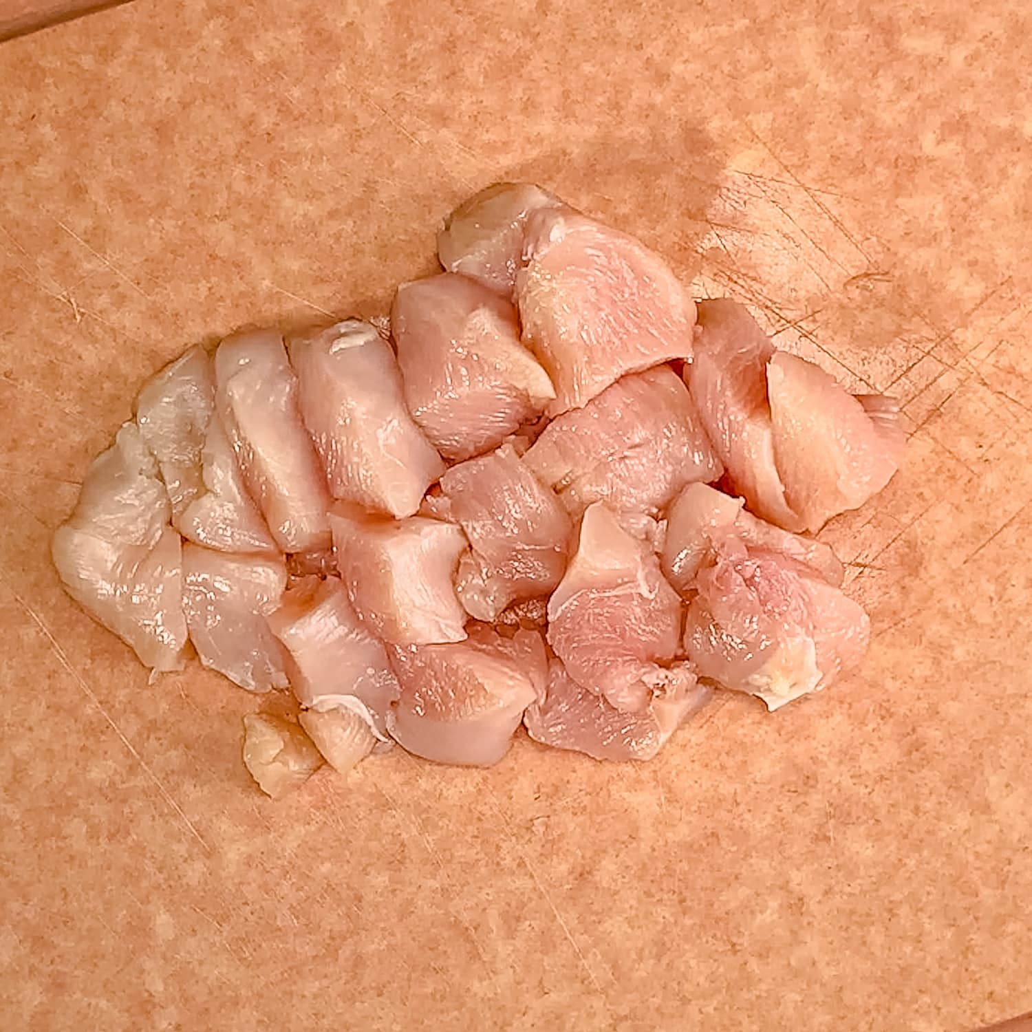 cubed chicken on a cutting board